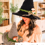 A woman holding a gray crocheted witch hat next to her own black version, both adorned with moss and mushrooms. Text overlay: “Wheat Stitch Witch Hat” and “Free Pattern + Video Tutorial.”