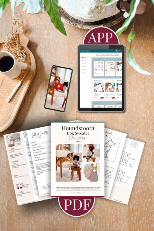 A tablet and smartphone displaying a crochet app, positioned above printed pattern pages for a houndstooth dog sweater.