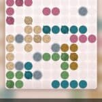 A grid-based crochet puzzle game titled “Just One More Row” featuring balls of yarn as playing pieces.