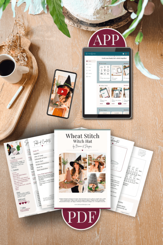 A tablet displaying a crochet app and a stack of printed Wheat Stitch witch hat patterns on a wooden table next to a cup of coffee.