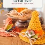Text overlay “Free crochet pattern: Mini Witch Hats for Fall Decor” above three handmade mini crochet witch hats in orange and yellow, decorated with faux leaves and twine.