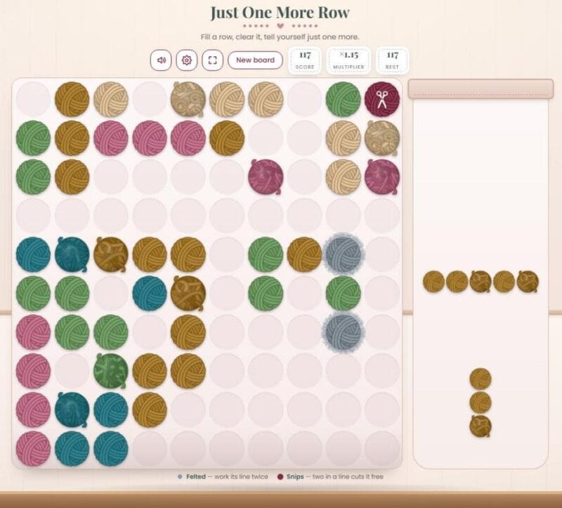 A Just One More Row board in the middle of a game, with a scissors snips ball and gray felted yarn balls on the board